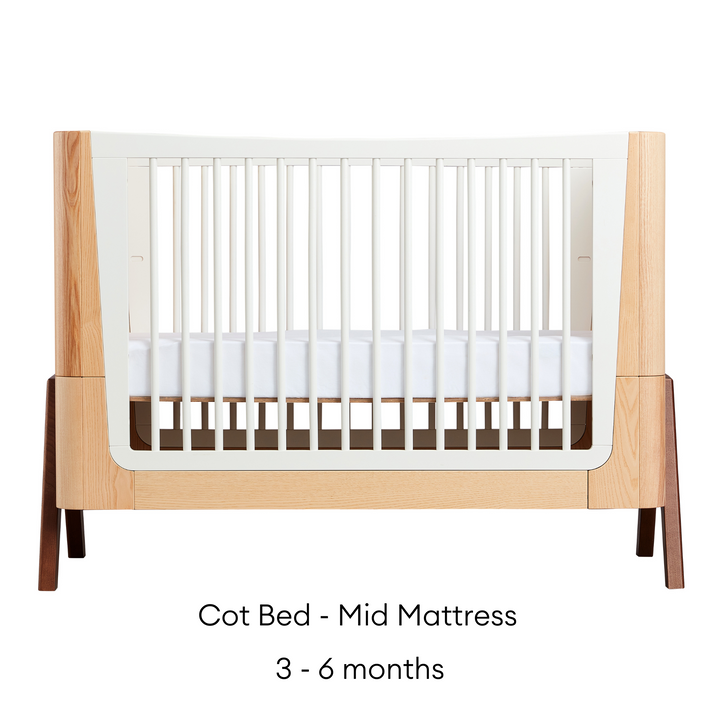 This image shows the stunning Gaia Baby Hera Cot Bed in the Natural Ash and Walnut colour swatch 