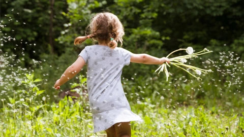 Little girl running on a field of flowers