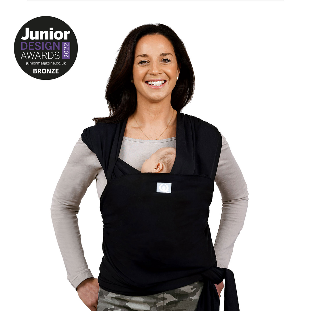 Model with a baby wearing Gaia Baby Stretchy Baby Wrap Pure Tencel™ in Ebony colour. The product won Bronze in Junior Design Awards 2022  