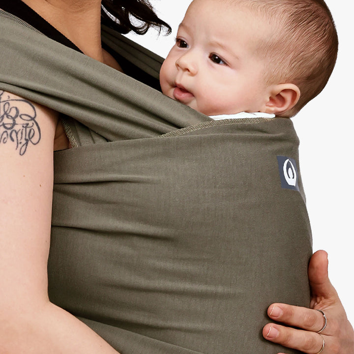 Model with a baby wearing Gaia Baby Carry Stretchy Baby Wrap Pure Tencel™ in Forest Green